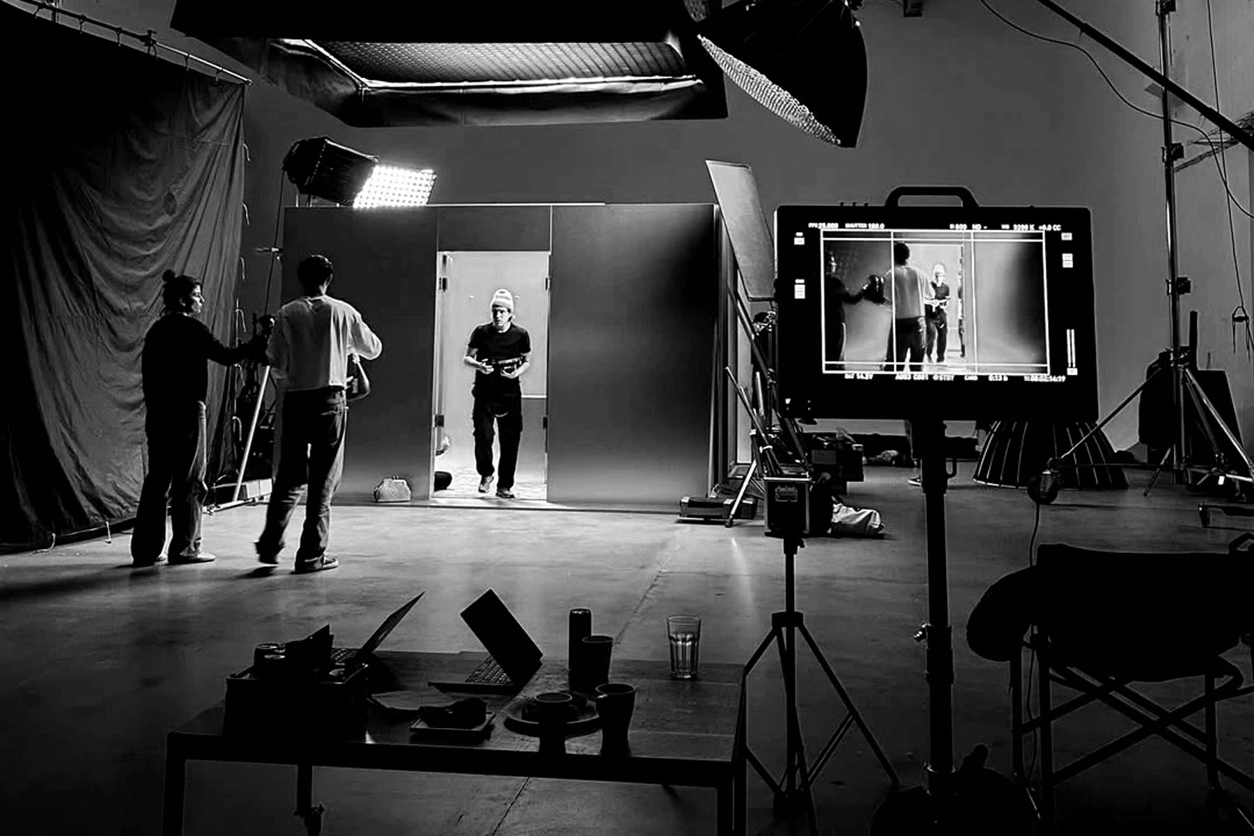 Set de filmagem com equipe, refletores e monitor de câmera