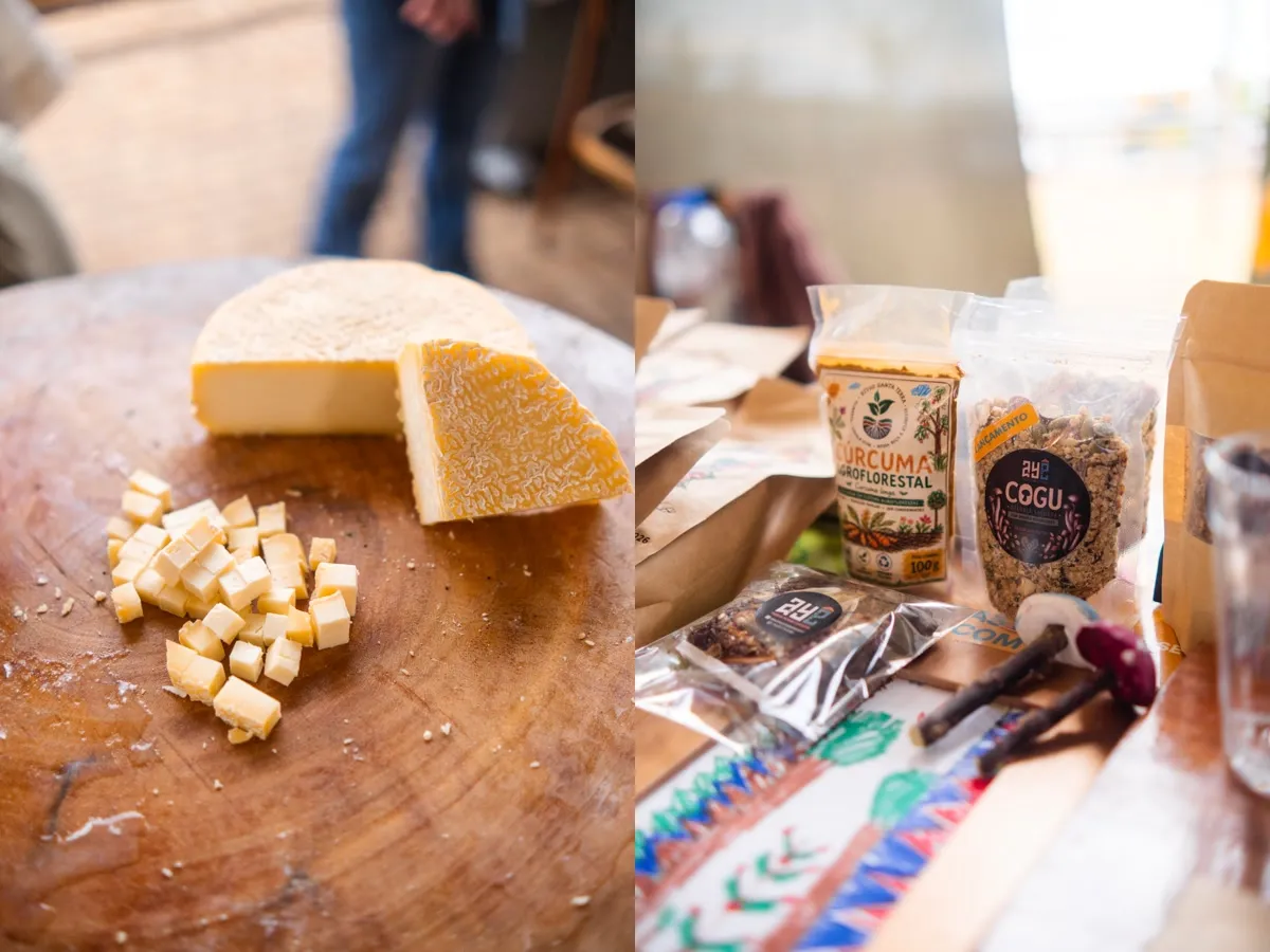 Queijo cortado em cubos sobre tábua e produtos expostos em uma mesa